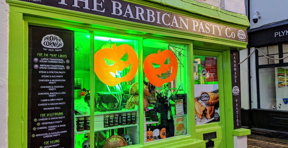Pumpkin decorations and green lights in the window of the Barbican Pasty Co shop